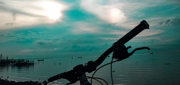 Silhouette ship in sea against sky at dusk