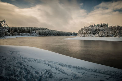 Scenic view of frozen lake against sky during winter