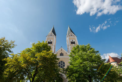 Low angle view of trees and building against sky