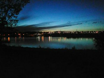 Scenic view of calm lake against sky at night