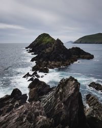 Rocks on sea shore against sky