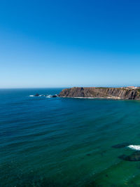 Scenic view of sea against clear blue sky