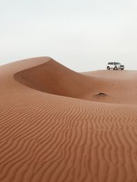 Sand dune in desert against clear sky