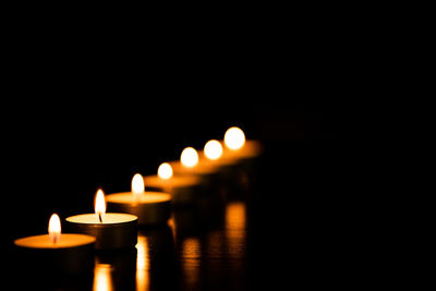 Close-up of lit candles in the dark