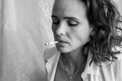 Close-up portrait of woman smoking cigarette