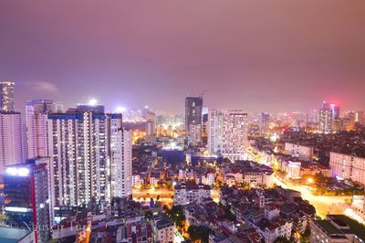 Illuminated cityscape against sky at night