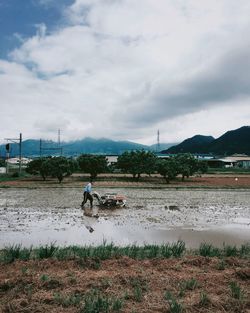 People on shore against sky