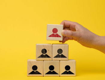 Female hand holds a wooden block on a blue background. recruitment concept, teamwork, 