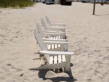 High angle view of empty bench on beach during sunny day