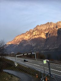 Road leading towards mountains against sky