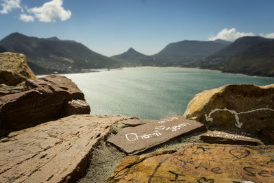 Close-up of text on rock against sky