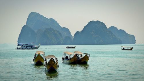 Boats moored in sea against clear sky