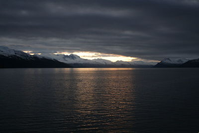 Scenic view of lake and mountains against sky during sunset