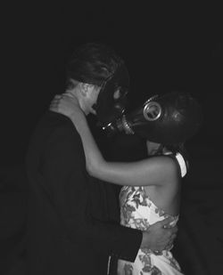 Rear view of couple holding hands against black background