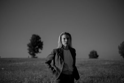 Portrait of a young woman standing on field