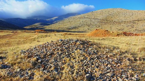 Stones on field against mountains