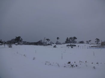 Scenic view of snow covered field against sky