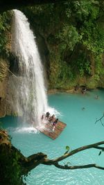 High angle view of people on wooden raft at waterfall