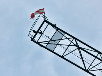 Low angle view of crane against clear blue sky