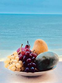 Close-up of grapes in container on table at beach