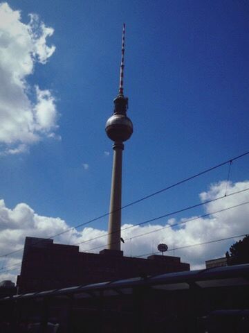 LOW ANGLE VIEW OF COMMUNICATIONS TOWER AND BUILDINGS AGAINST SKY