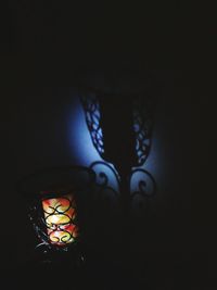 Close-up of illuminated electric lamp in darkroom