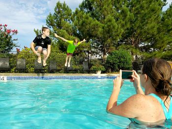 Children jumping into swimming pool