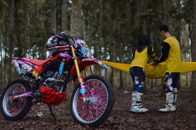 People riding motorcycle in forest