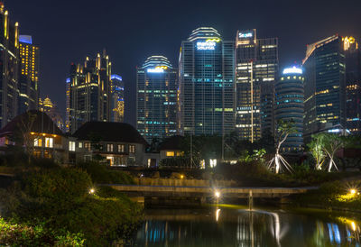 Illuminated modern buildings against sky at night