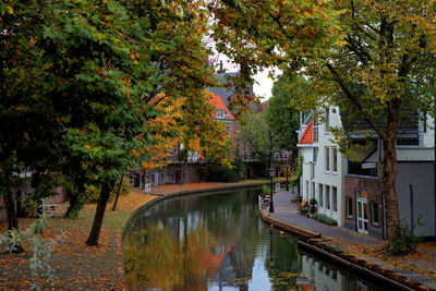 Canal amidst trees and buildings during autumn