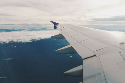 Close-up of airplane wing against sky