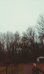 Man by trees against sky