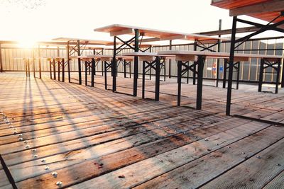 Empty chairs and table against sky during sunset