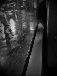 Woman seen through wet glass window in rainy season