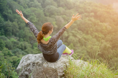 High angle view of woman sitting on rock