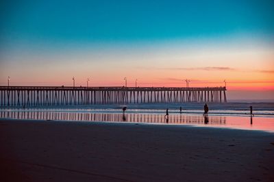 Pier over sea against sky during sunset