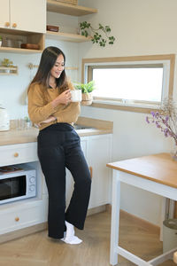 Side view of young woman sitting on table