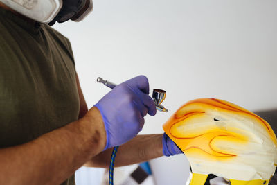 Close up of painter's hands painting flames on helmet.