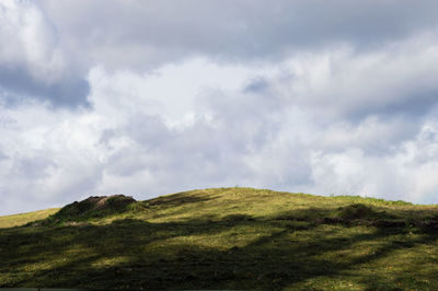 Countryside landscape against cloudy sky