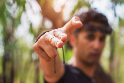 Close-up of young man holding plant