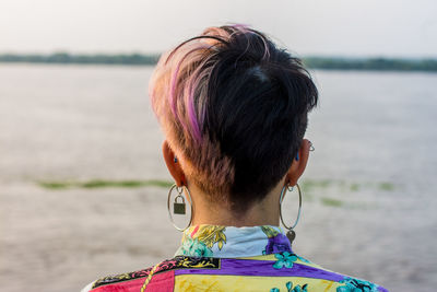 Rear view of woman with short hair looking at sea