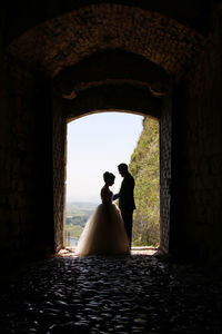 Rear view of woman standing in tunnel