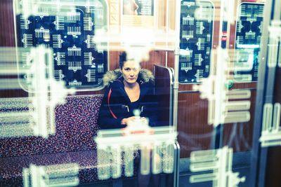 Woman looking through window at store