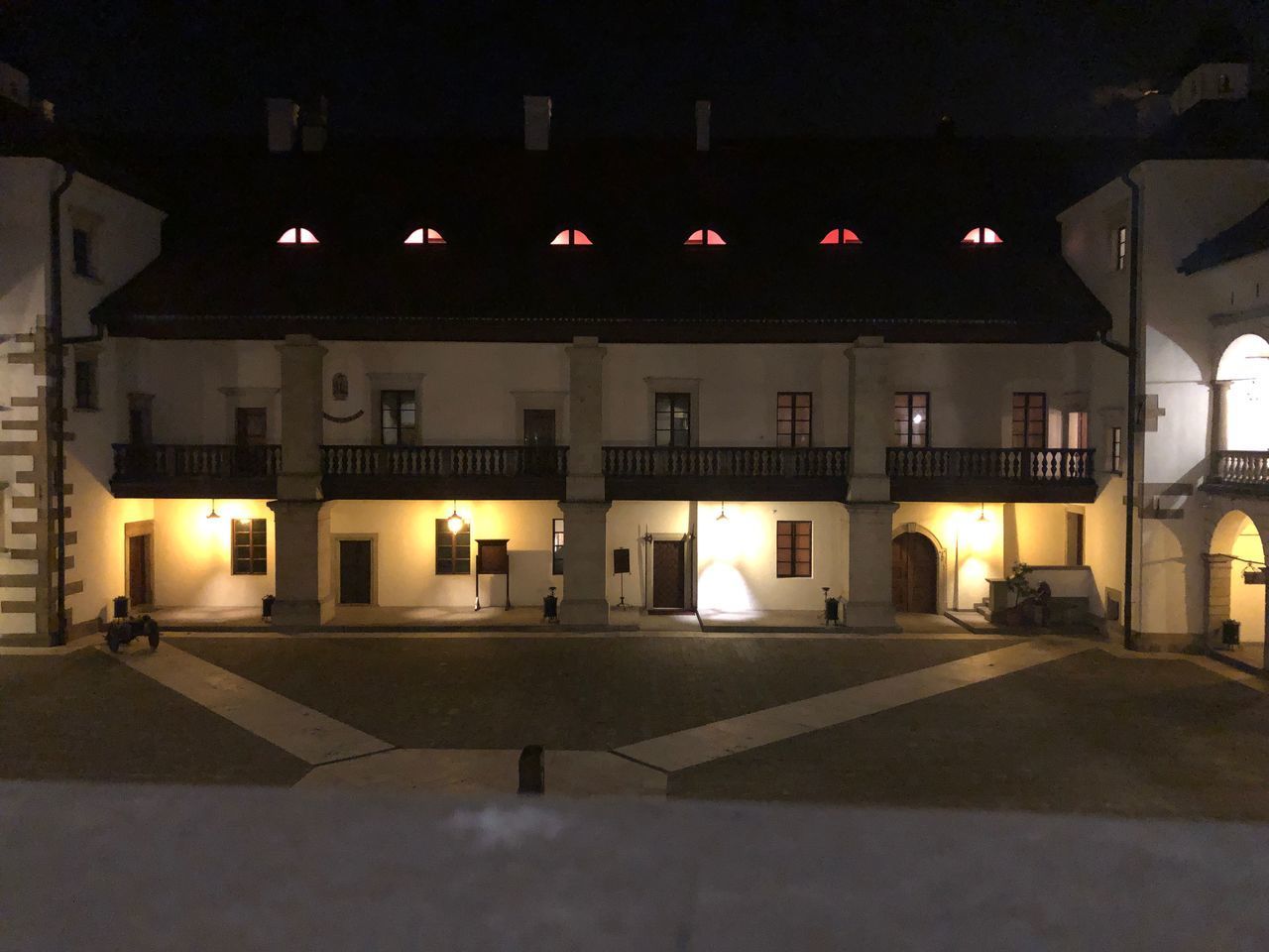 ILLUMINATED PARKING LOT BY BUILDING AT NIGHT