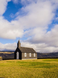 Barn on field against sky