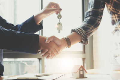 Midsection of couple holding hands on table