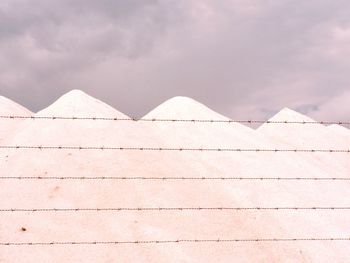 Low angle view of building wall against sky