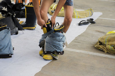 Low section of people holding umbrella on floor