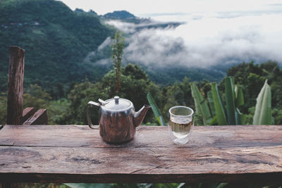 Wine glasses on table against mountains