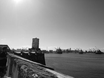 Bridge over sea against buildings